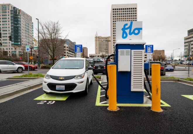 electric vehicle parked in a downtown lot plugged into a Flo charger