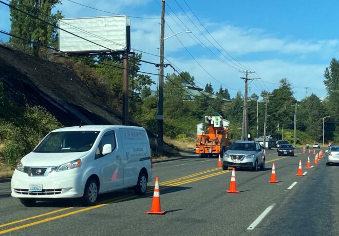 Utility truck in the road with other cars driving by