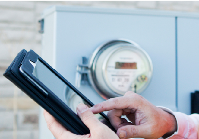 Person using an ipad in front of a residential electric meter