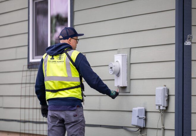 Filed Investigator checking an electric meter on the side of a home.