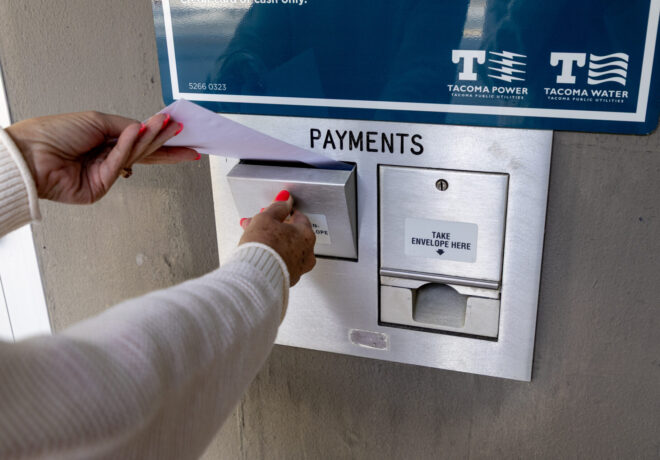 Picture of a person putting an envelope in the drop box at Tacoma Public Utilities.