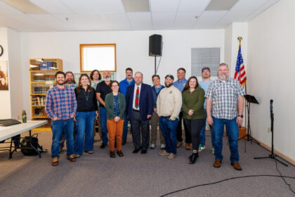 Staff stand together and smile at the Cowlitz Fisheries Science Conference and Annual Program Review