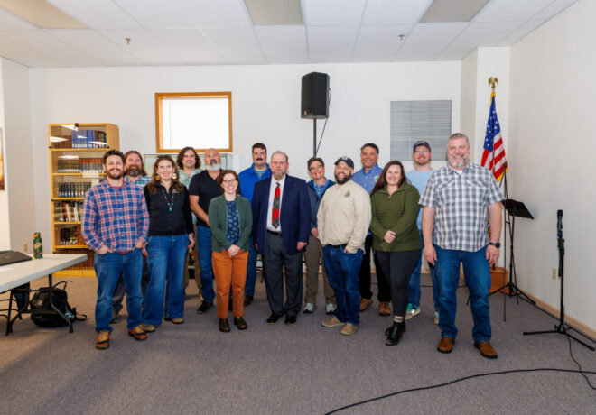 Staff stand together and smile at the Cowlitz Fisheries Science Conference and Annual Program Review