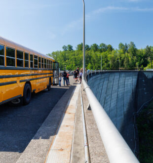 a school bus next to a hydro project dam
