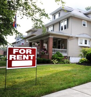 An image of a home with a For Rent sign in the front yard.