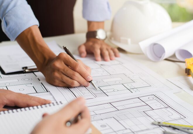 Close-up of an engineer planning a hand-drawn design. with architect equipment Architects talking at the table Teamwork and workflow concepts