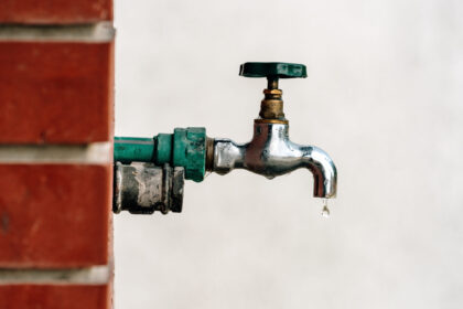 Back yard outdoor garden faucet with drop of water.