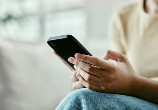 image of a Person hand's with smartphone receiving an outage update