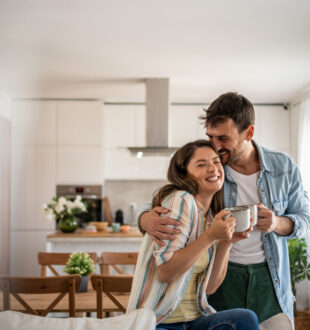 image of Young couple drinking morning coffee enjoying the weekend in their upgraded apartment