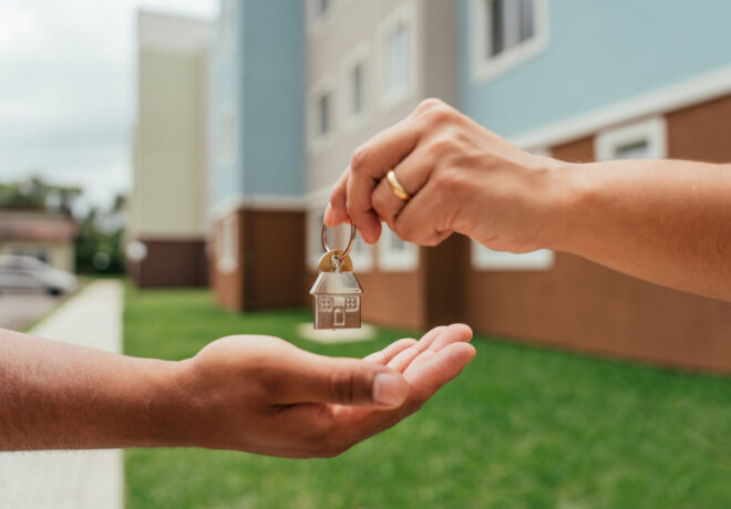 Close-up of a property management agent handing house keys to a renter.