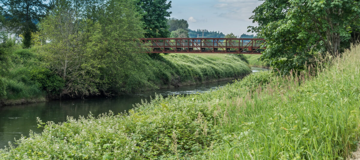 A metal bridge spans the Green River in Kent, Washington.