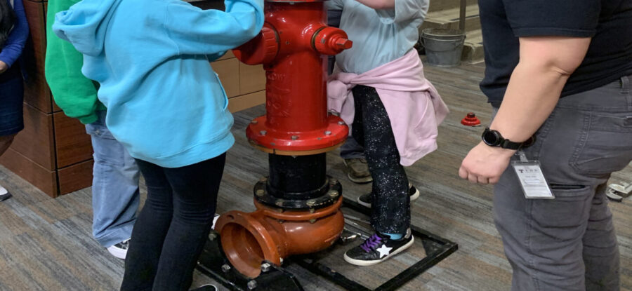 Girl Scouts and water utility workers build a fire hydrant at Steps to STEM April 2025