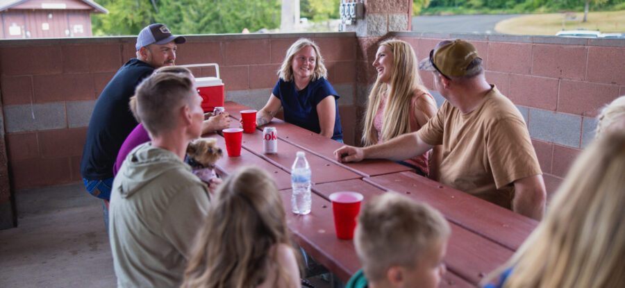 friends eating at a picnic table in a kitchen shelter