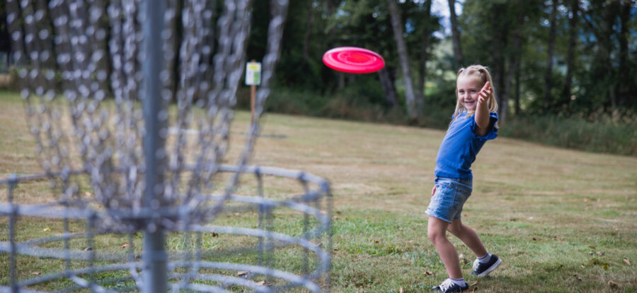 girl throwing disc golf