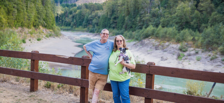 couple in front of stream with dog