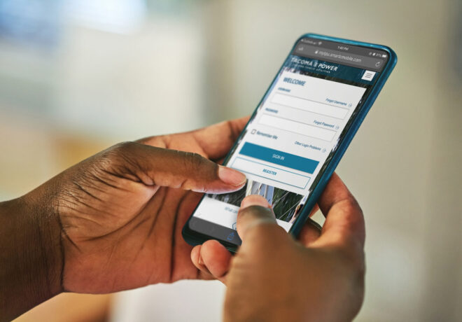 Hands holding a smartphone with the login to MyAccount featured.